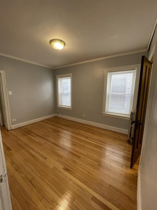 spare room featuring crown molding and light wood-style flooring