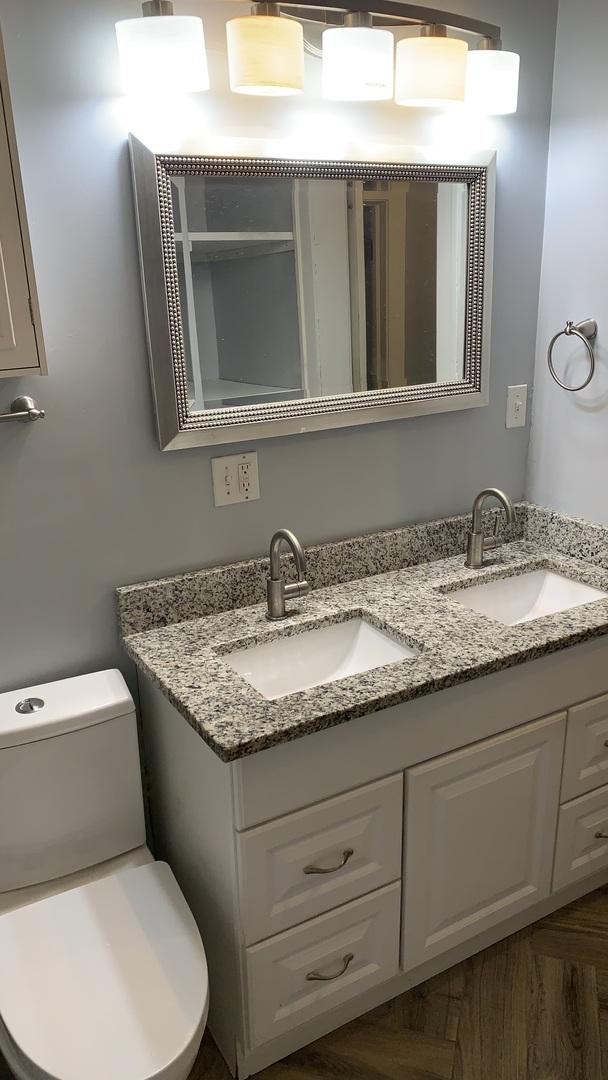 bathroom with double vanity and toilet