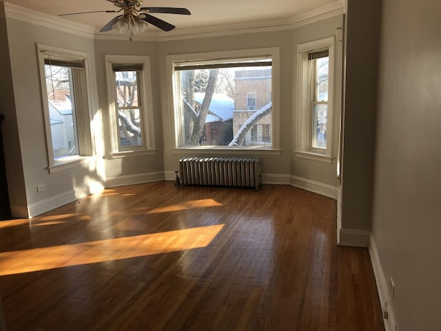 spare room with radiator, ornamental molding, ceiling fan, and hardwood / wood-style flooring