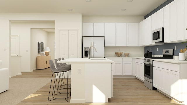 2909 Kelly Dr, Elgin, IL 60124 - kitchen featuring stainless steel range with gas cooktop, refrigerator with ice dispenser, light wood-style floors, a breakfast bar area, and an island with sink