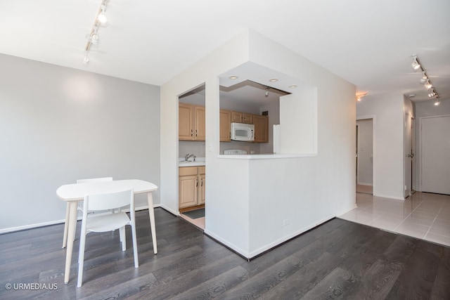 3900 N Lake Shore Dr Unit 3E, Chicago, IL 60613 - kitchen featuring white microwave, rail lighting, dark wood-type flooring, and light countertops