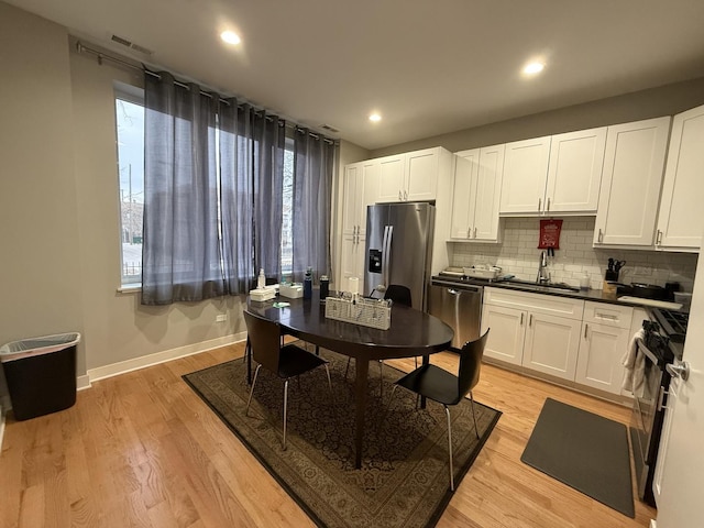 1017 S Claremont Ave, Chicago, IL 60612 - kitchen with appliances with stainless steel finishes, backsplash, white cabinets, dark countertops, and recessed lighting