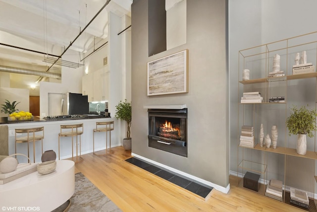 1000 W Washington Blvd Unit 320, Chicago, IL 60607 - living area featuring wood finished floors, a lit fireplace, and a towering ceiling