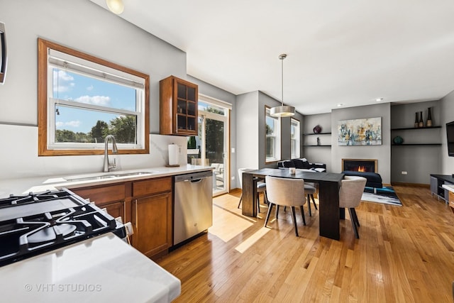 1581 Kenmore Ave, Aurora, IL 60505 - kitchen with stainless steel dishwasher, brown cabinetry, light wood-style flooring, light countertops, and open floor plan