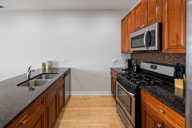 3126 W Walton St Unit 2, Chicago, IL 60622 - kitchen with stainless steel appliances, backsplash, light wood-style flooring, and dark stone counters