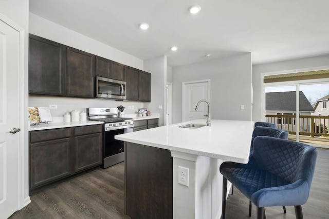 2621 Harnish Dr, Algonquin, IL 60102 - kitchen with stainless steel appliances, dark wood-type flooring, a kitchen breakfast bar, dark brown cabinetry, and recessed lighting