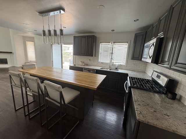 4550 Columbine Ln, Matteson, IL 60443 - kitchen with stainless steel appliances, butcher block counters, backsplash, a breakfast bar, and a kitchen island