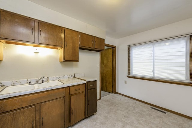 221 Kenwood Dr, Round Lake Park, IL 60073 - kitchen with light countertops, brown cabinetry, and light floors