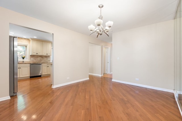 3528 Riverside Dr, Wilmette, IL 60091 - spare room with a chandelier and light wood-style flooring