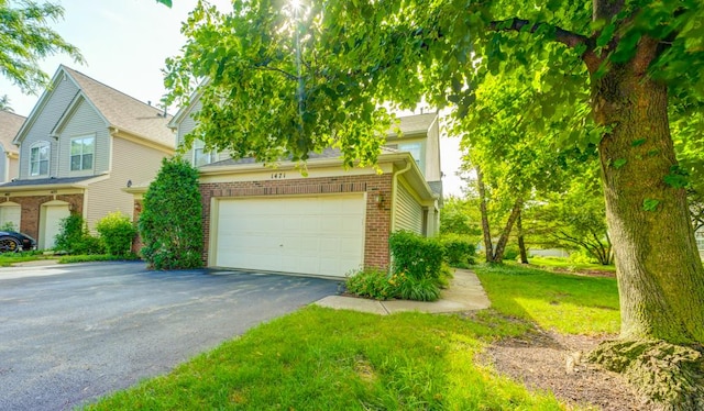 1471 Doolittle Ln, Grayslake, IL 60030 - view of property hidden behind natural elements featuring driveway, brick siding, a garage, and a front yard