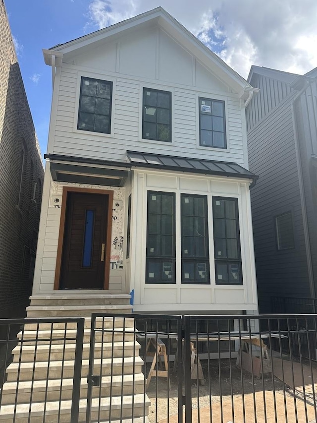 2203 W Huron Ave, Chicago, IL 60622 - view of front facade with a fenced front yard, a standing seam roof, and a metal roof