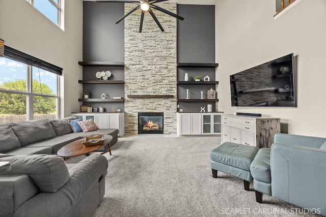 854 Preston Ln, Oswego, IL 60543 - carpeted living area featuring a towering ceiling, ceiling fan, plenty of natural light, a stone fireplace, and built in features