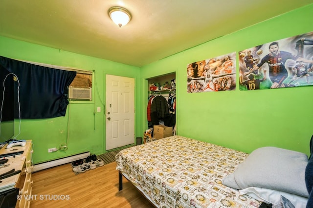 1107 E Algonquin Rd Unit 19, Arlington Heights, IL 60005 - bedroom featuring a baseboard heating unit, wood finished floors, and a closet