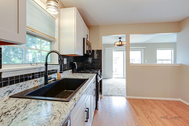 1186 Ballantrae Pl Unit D, Mundelein, IL 60060 - kitchen featuring appliances with stainless steel finishes, light wood-style flooring, white cabinets, and healthy amount of natural light