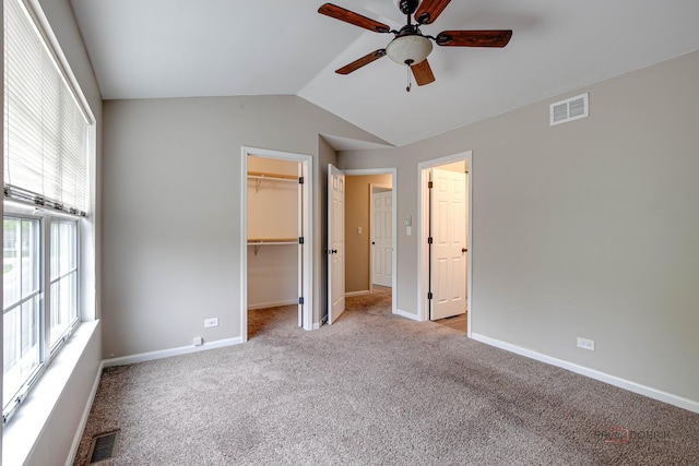 1186 Ballantrae Pl Unit D, Mundelein, IL 60060 - unfurnished bedroom featuring light carpet, lofted ceiling, a walk in closet, a closet, and ceiling fan
