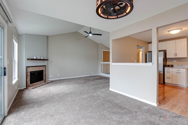 1186 Ballantrae Pl Unit D, Mundelein, IL 60060 - unfurnished living room featuring light carpet, plenty of natural light, vaulted ceiling, and a tiled fireplace
