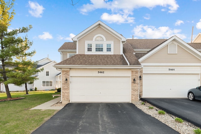5462 Ridge Xing, Hanover Park, IL 60133 - traditional home with asphalt driveway, brick siding, a shingled roof, and a front lawn