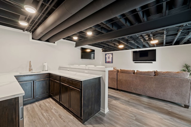5462 Ridge Xing, Hanover Park, IL 60133 - kitchen featuring dark brown cabinetry, light wood finished floors, open floor plan, a peninsula, and light stone counters
