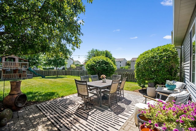 2551 Fallbrook Dr, Hampshire, IL 60140 - fenced backyard featuring a patio area, a playground, and outdoor dining area
