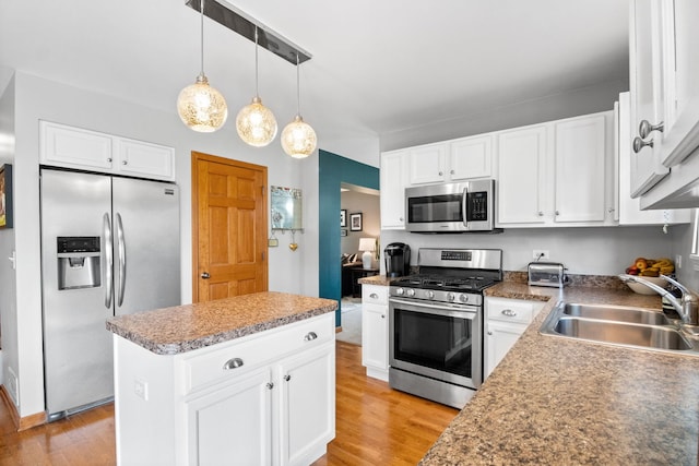 2551 Fallbrook Dr, Hampshire, IL 60140 - kitchen with stainless steel appliances, light wood-style flooring, a kitchen island, hanging light fixtures, and white cabinetry