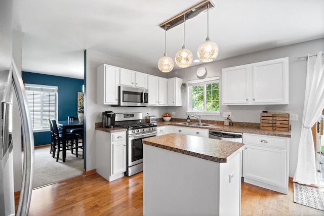 2551 Fallbrook Dr, Hampshire, IL 60140 - kitchen featuring appliances with stainless steel finishes, white cabinets, a kitchen island, and light wood finished floors