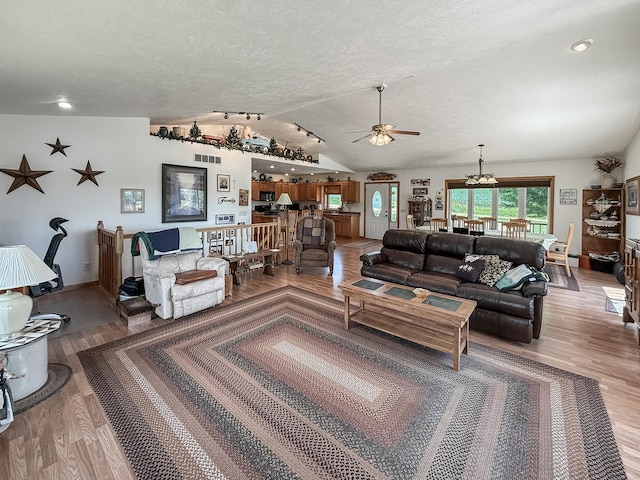 5782 N Brown Rd, Dakota, IL 61018 - living area featuring light wood-style flooring, lofted ceiling, ceiling fan, a textured ceiling, and a chandelier