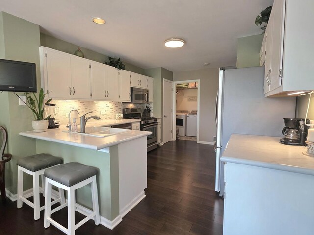 17207 Arrow Head Dr, Lockport, IL 60441 - kitchen featuring stainless steel appliances, washing machine and clothes dryer, decorative backsplash, a peninsula, and white cabinetry