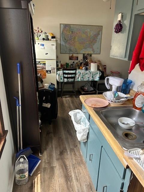 2431 W Thomas St, Chicago, IL 60622 - kitchen featuring dark wood-style flooring, blue cabinets, and freestanding refrigerator