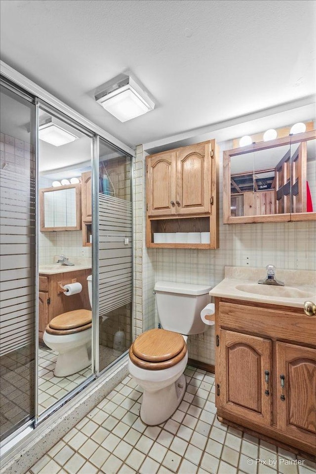 335 Arlington Rd, Itasca, IL 60143 - bathroom with vanity, a shower stall, and tile walls