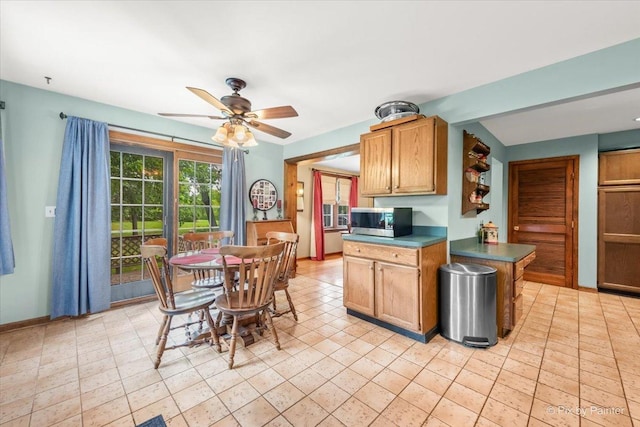 335 Arlington Rd, Itasca, IL 60143 - kitchen with stainless steel microwave, a ceiling fan, dark countertops, and light tile patterned floors