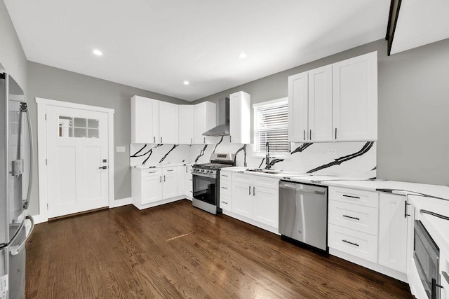 5414 W Haddon Ave, Chicago, IL 60651 - kitchen featuring appliances with stainless steel finishes, wall chimney exhaust hood, light countertops, white cabinets, and dark wood-type flooring