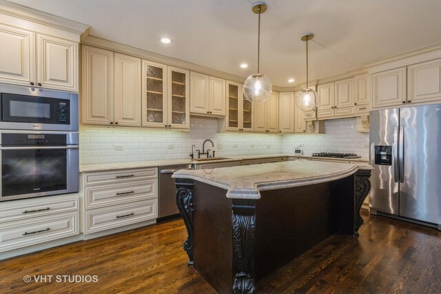 1302 N Bosworth Ave Unit 1, Chicago, IL 60642 - kitchen with stainless steel appliances, light stone counters, tasteful backsplash, a kitchen island, and dark wood finished floors