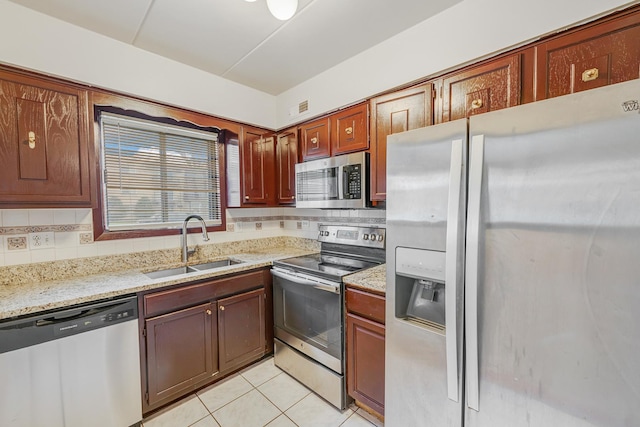 5715 129th St Unit 1A, Crestwood, IL 60418 - kitchen with appliances with stainless steel finishes, light tile patterned flooring, tasteful backsplash, and light stone counters