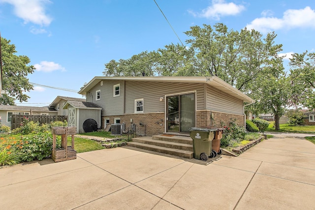 5754 150th St, Oak Forest, IL 60452 - rear view of property with brick siding, a storage unit, and a patio area