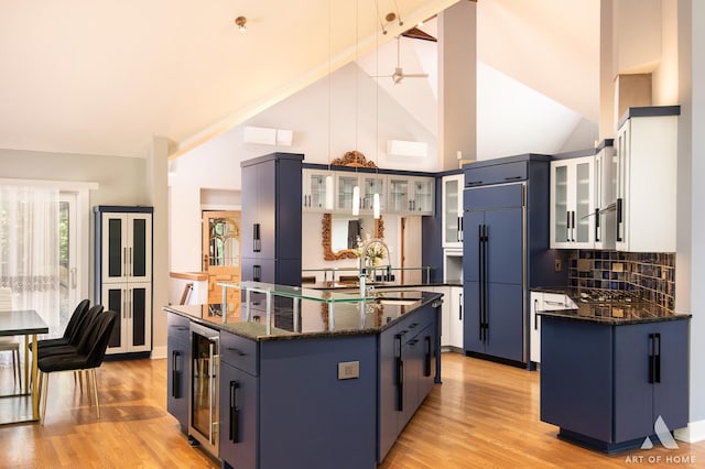 113 Oak Ridge Dr E, Burr Ridge, IL 60527 - kitchen featuring paneled built in fridge, beverage cooler, a kitchen island with sink, high vaulted ceiling, and decorative backsplash