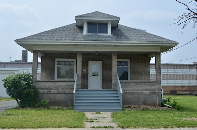 12005 4th St, Huntley, IL 60142 - view of front facade with brick siding, a porch, roof with shingles, and a front lawn