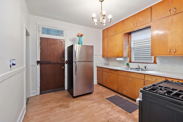 7933 S Burnham Ave, Chicago, IL 60617 - kitchen featuring freestanding refrigerator, light countertops, light wood-type flooring, and a chandelier