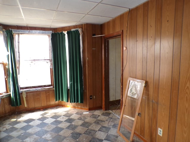 8417 S Mackinaw Ave, Chicago, IL 60617 - unfurnished room with wooden walls, tile patterned floors, and a drop ceiling