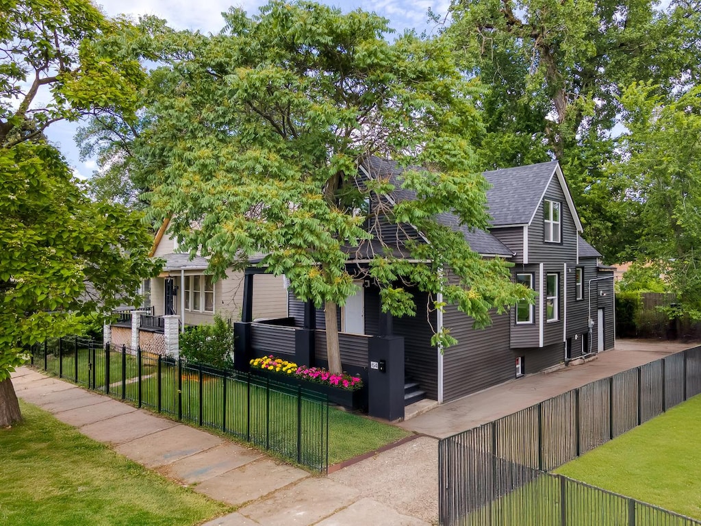64 E 102nd Pl, Chicago, IL 60628 - view of front of home with a shingled roof and a fenced front yard