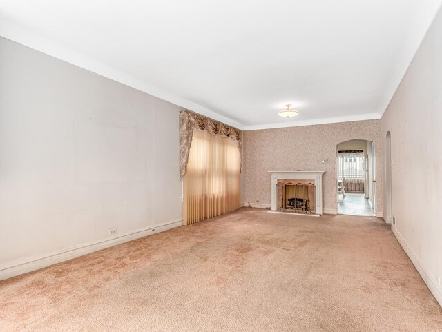 4923 W School St, Chicago, IL 60641 - unfurnished living room featuring arched walkways, light carpet, a fireplace, and wallpapered walls