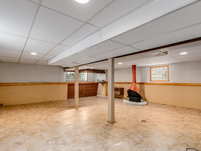4923 W School St, Chicago, IL 60641 - below grade area with a paneled ceiling, a wood stove, and tile patterned floors