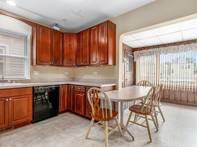 4923 W School St, Chicago, IL 60641 - kitchen featuring black dishwasher, a kitchen bar, light countertops, and light floors