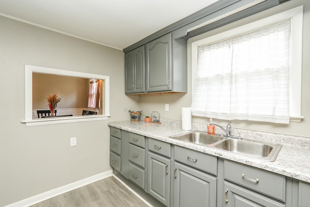 514 E Beaudoin St, Bourbonnais, IL 60914 - kitchen with gray cabinetry, light wood finished floors, light countertops, and ornamental molding