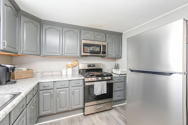 514 E Beaudoin St, Bourbonnais, IL 60914 - kitchen featuring appliances with stainless steel finishes, gray cabinets, light wood finished floors, and crown molding