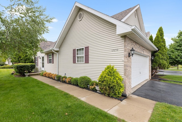 12050 Baneberry Dr Unit 9, Roscoe, IL 61073 - view of side of home featuring a yard, driveway, roof with shingles, and an attached garage