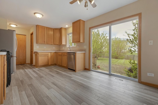 838 Valley Stream Dr, Pingree Grove, IL 60140 - kitchen with stainless steel dishwasher, light countertops, light wood-style floors, ceiling fan, and freestanding refrigerator