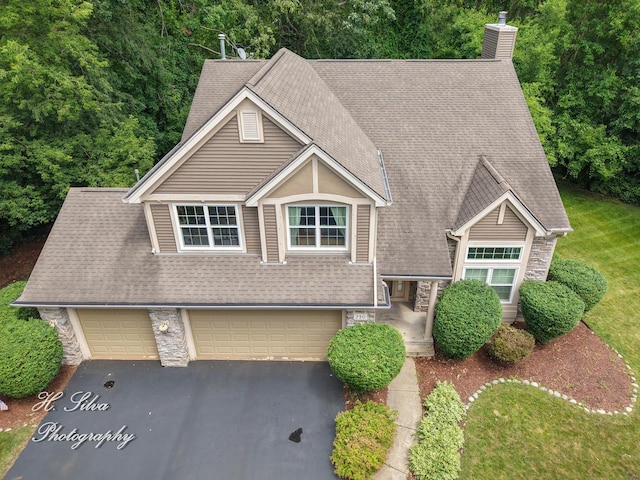 750 Seybrooke Ln, Crystal Lake, IL 60012 - view of front of house featuring stone siding, a chimney, driveway, and roof with shingles