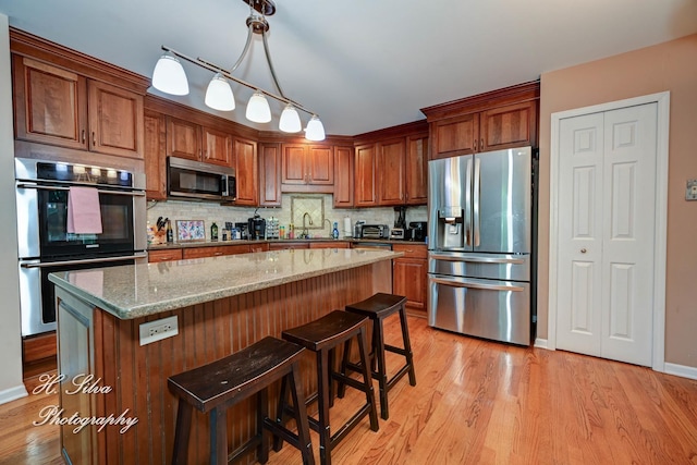 750 Seybrooke Ln, Crystal Lake, IL 60012 - kitchen featuring appliances with stainless steel finishes, light wood-type flooring, backsplash, and a center island