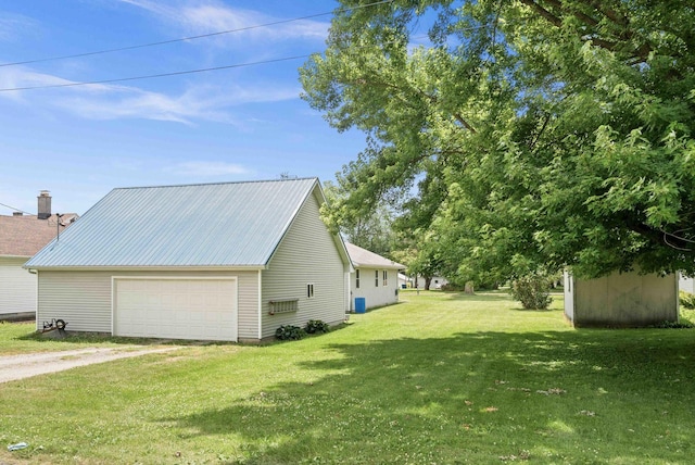 101 W Olive St, Colfax, IL 61728 - view of property exterior with a yard, a detached garage, and a metal roof