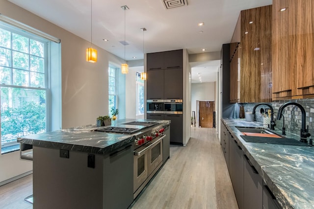 1401 N Astor St, Chicago, IL 60610 - kitchen with range with two ovens, modern cabinets, light wood-style floors, brown cabinetry, and tasteful backsplash